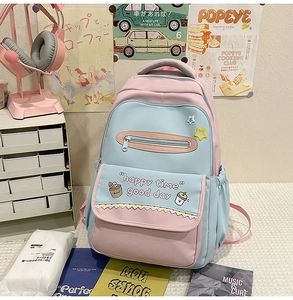 Detail of pink and blue contrast school backpack with cute prints on a student desk