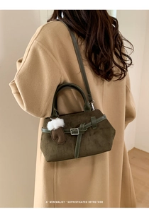 Détail du sac à main en daim vert olive avec sangle décorative et pendentif gant unique