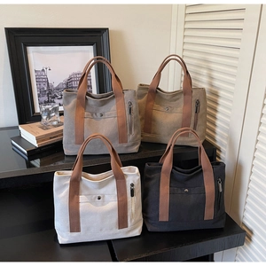 Macro shot of stylish canvas tote bags in four colors with brown straps and snap pockets