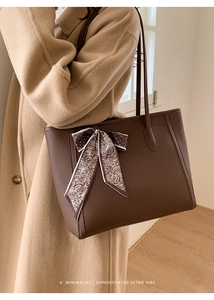 Close-up of a dark brown pebble leather tote bag featuring a vintage pattern silk scarf
