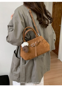 Détail du sac à main rétro en daim marron avec breloque cœur et boucle argentée