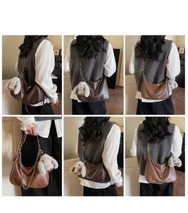 Detailed views of brown faux leather baguette bag with silver chain and rabbit charm
