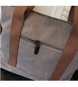 Close-up of a blue canvas tote bag showing the smooth metal zipper and reinforced stitching