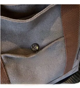 Macro shot of luxury magnetic snap hardware and textured blue canvas on tote bag