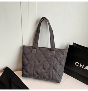 Detail shot of grey quilted nylon tote bag with rhombus pattern and long shoulder straps