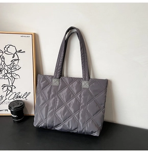Detail of grey quilted tote bag with diamond stitching and large capacity for commuting