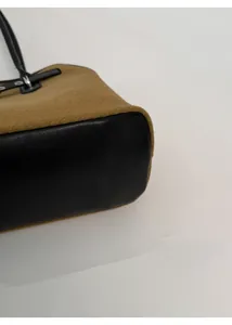 Detail of reinforced wide leather base and textured suede fabric on tote bag