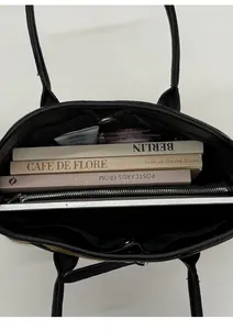 Interior view of black leather tote bag showing large capacity and multi-compartment storage