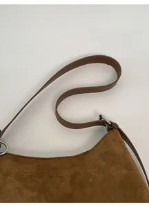 Détail de la bandoulière réglable en daim avec boucle argentée sur sac fourre-tout