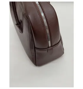 Detailed macro view of dark brown soft leather Boston bag with silver metal zipper