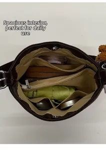 Intérieur spacieux d'un sac seau marron avec plusieurs poches et grande capacité de rangement