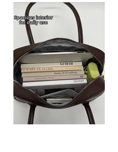 Top view of spacious interior of dark brown soft leather Boston bag with stripe lining
