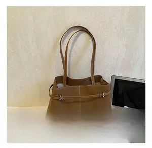 Detail of brown faux leather tote bag with metal buckles and white contrast stitching