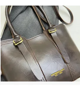Detail of vintage brown leather bucket bag showing oil wax texture and gold stamping