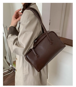 Deep brown faux leather Boston bag detail showing top handles and smooth texture finish