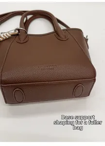 Detail showing the structured base craft of the brown leather bucket bag for a full shape