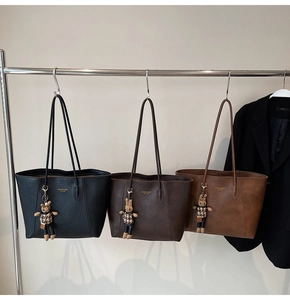Detailed close-up of large tote bags in black, coffee, and brown with rabbit charms