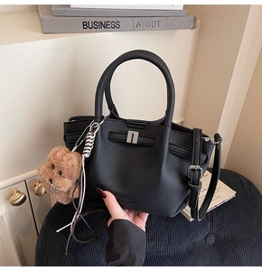 Gros plan sur le sac à main en cuir grainé noir avec boucle et porte-clé ours