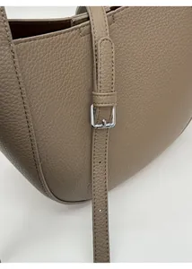 Detail of adjustable silver buckle on taupe lychee pattern leather shoulder bag strap