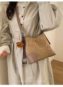 Détail du sac cabas rétro en daim avec garniture en cuir et charmant ours en peluche