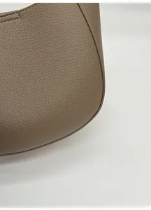 Close-up of tan lychee grain leather texture with premium stitching details on bucket bag