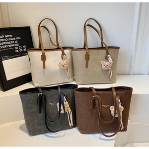 Detail view of retro matte leather tote bags in four colors with bear charms and scarves