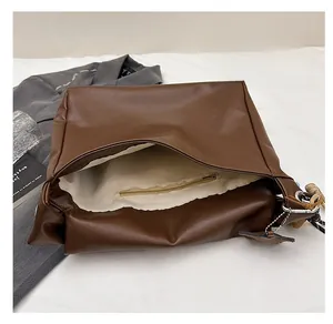Detailed interior of brown oil wax leather tote bag showing white lining and zip pocket