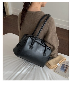 Retro black leather underarm tote bag with glossy texture worn at a 45-degree angle