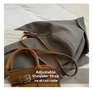 Close-up of adjustable shoulder strap on brown lychee grain leather bowling bag