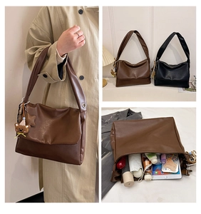 Detail showing high-capacity interior of soft brown leather tote bag with various items
