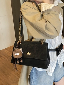 Retro black suede shoulder bag with gold chain strap and cute monster plush pendant