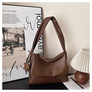 Detail of deep brown oil wax leather tote bag with star pendant in vintage room setting