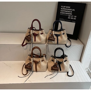 Chic woven bucket bags in four colors arranged on marble steps for a modern fashion look