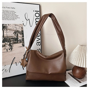 Close-up of brown faux leather tote bag with flap closure and cute star charm detail