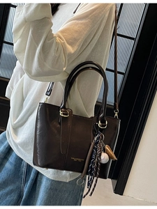 Retro dark brown leather tote bag with stylish charms and adjustable shoulder strap