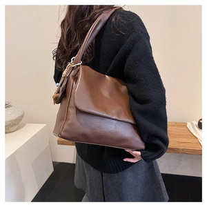 Detailed view of deep brown large tote bag in oil wax leather finish with shoulder strap