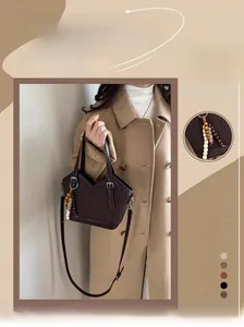 Detail der dunkelbraunen Beuteltasche mit Faltenstruktur und buntem Perlenquasten-Anhänger