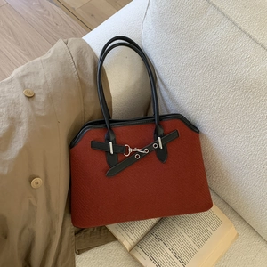Detail of red-brown twill texture and black leather handle with silver metal hook