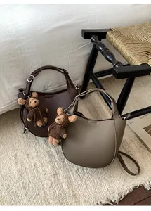 Chic half-moon leather bucket bags in chocolate and khaki with cute teddy bear charms