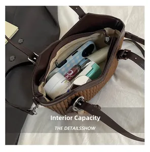 Vue intérieure du sac seau marron matelassé avec rangement pour téléphone et cosmétiques