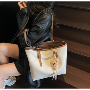 Detail of the minimalist tote bag featuring cream PU leather and brown trim accents