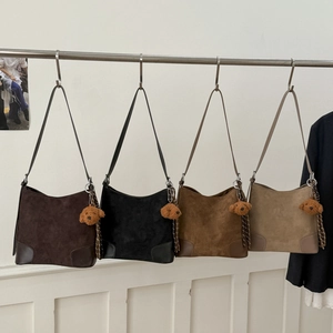 Detail view of retro matte suede bucket bags in four colors with teddy bear charms