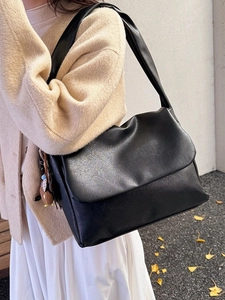 Minimalist black oil wax leather tote bag with brown bear charm shown on model