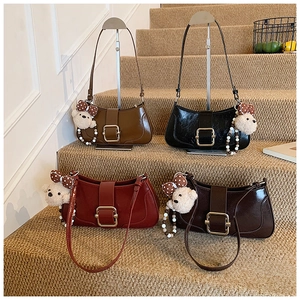 Détail de sacs baguette vintage en quatre couleurs avec breloques d'ours en peluche