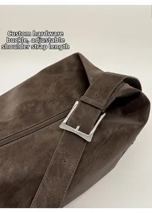 Detail of dark brown tote bag showing the adjustable silver buckle and lychee texture