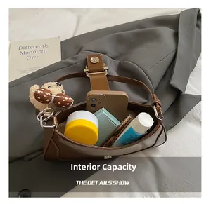Detail view of brown vintage handbag interior showing storage for phone and cosmetics