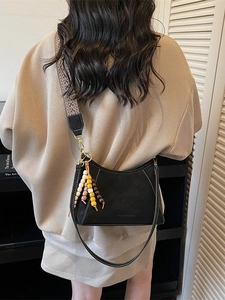 Bolso retro negro de media luna con correa étnica ancha y dijes de cuentas de madera