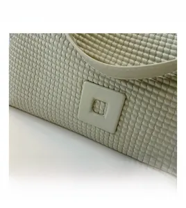 Dettaglio della borsa con trama a nido d'ape e fibbia quadrata in stile minimalista