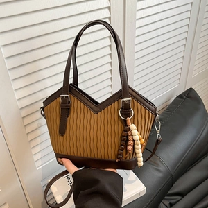 Detail der Retro-Beuteltasche mit vertikalen Falten und Bohème-Perlenanhänger