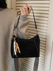 Bolso tote negro retro con costuras blancas y colgante de cuentas decorativo en la correa